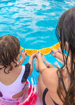 Children eating watermelon by the pool. Selective focus.