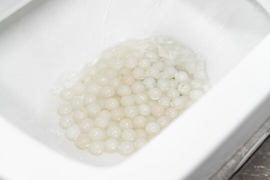 Test the toilet's flushing ability by dropping an object into it.