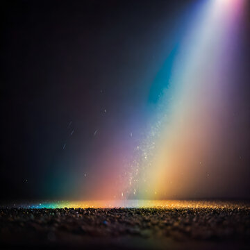 Light beams shine through dark atmospheric fog to illuminate a gritty textured ground surface.