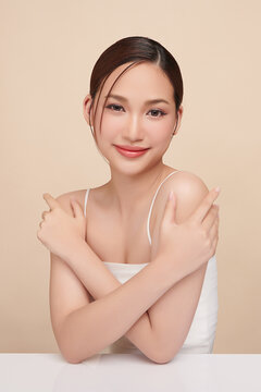 A beautiful young Asian woman with clean, fresh skin against a beige background. Skincare, facial treatment, cosmetology, beauty, and spa. An elegant portrait of an Asian woman.