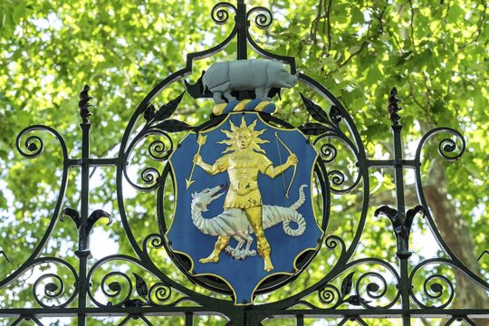 The Greek god Apollo (god of light, healing and medicine) with an arrow, bow and a halo, the coat of arms of the Worshipful Society of Apothecaries on the entrance gate, Chelsea Physic Garden, a historic botanical garden and the oldest botanical garden in London, founded in 1673 by the Worshipful Society of Apothecaries, Chelsea, England, United Kingdom