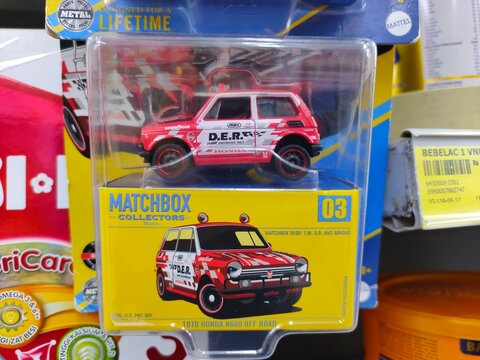 Malang, Indonesia - July 18, 2026:A red Matchbox Collectors 1970 Honda N600 Off Road die-cast car in its yellow and clear plastic display box.