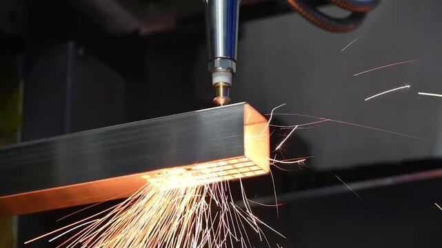 Slow motion footage of fiber laser cutting machine engraving and cutting square tube metal