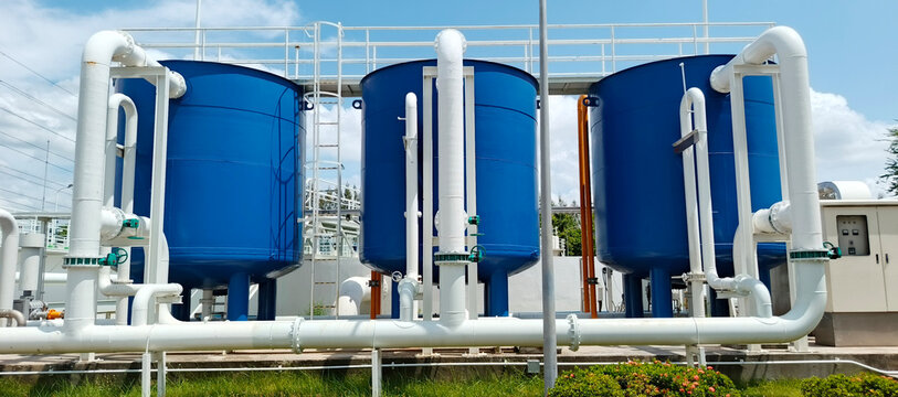 Large Blue Industrial Water Filtration Tanks with Pipeline System at Modern Treatment Plant