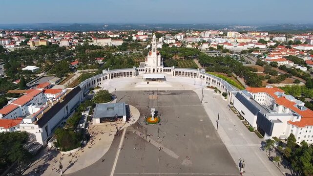 Dramatic aerial reverse shot revealing the sanctuary of fatima, including the basilica of our lady of the rosary and the vast esplanade, a major catholic pilgrimage site in portugal
