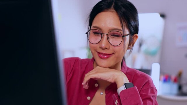 Asian woman eyeglasses computer office smile worker watch desk workplace doctor clinic healthcare medical portrait in pink uniform working at desk with screen calm focused modern examination room