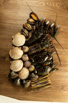 Seafood display with various shellfish and crustaceans on wooden surface