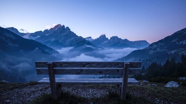 Wooden Bench Overlooking Misty Mountain Peaks at Dawn