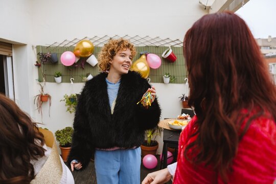 Two female friends talking together at a birthday party on an apartmen