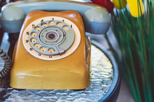 Vintage rotary dial telephone wheel. Circular rotary dial wheel with numbers from 1 to 0 of an antique beige telephone. Nostalgic details and retro textures of analog communication technology concept.