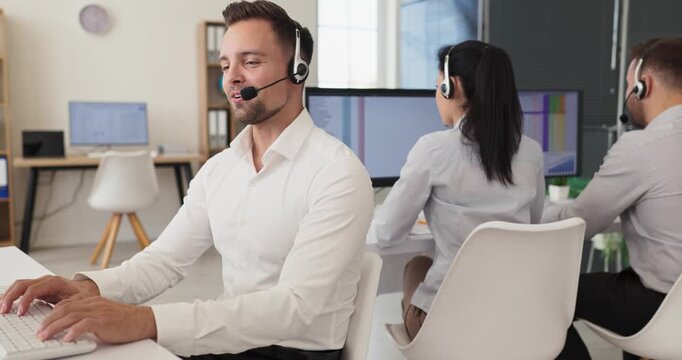 Operator agent in call center with headset. In a bright office a skilled team delivers customer support and service while typing at a computer. Ideal for customer support and communication.