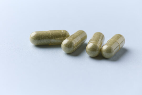 Barley grass capsules. Antioxidants. Concept for a healthy dietary supplementation. Bright background. Soft focus. Close up. Copy space.