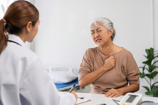 Senior Asian woman experiencing chest pain during medical consultation