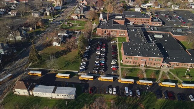 Aerial view of American public school campus with yellow school buses in the United States