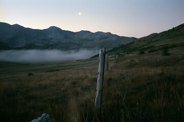 Fototapeta premium Alpine tundra at twilight with ground fog and boundary post