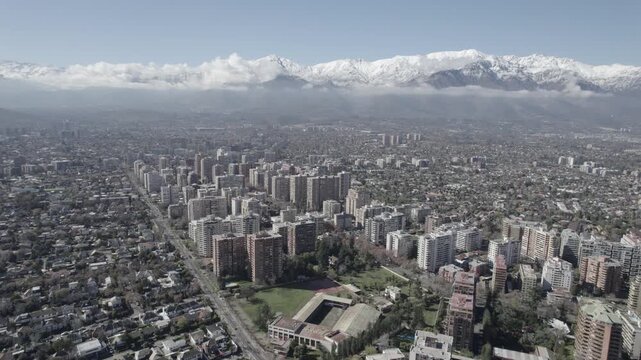 Aerial Drone Shot Of Santiago De Chile Cityscape Facing The Snow Covered Andes Mountains 