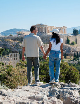 Couple enjoying a romantic stroll with the Acropolis in Athens, Greece