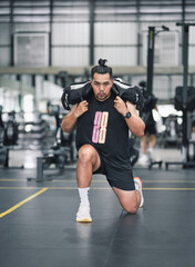 Fototapeta premium Man doing lunges with weighted bag in gym