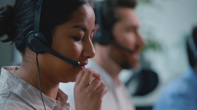 Arabian business woman customer support operator talking with headset in modern call center with multiracial team female helpline agent talk consultation assistance to clients in office callcenter