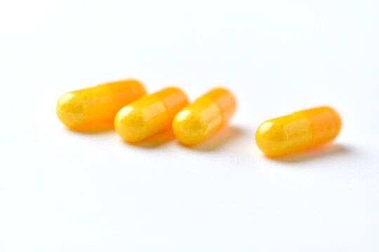 Vitamin C capsules. Antioxidants. Concept for a healthy dietary supplementation. Bright paper background. Soft focus. Close up. Copy space.
