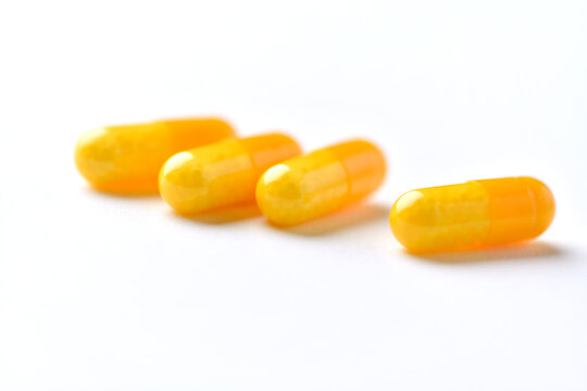 Vitamin C capsules. Antioxidants. Concept for a healthy dietary supplementation. Bright paper background. Soft focus. Close up. Copy space.