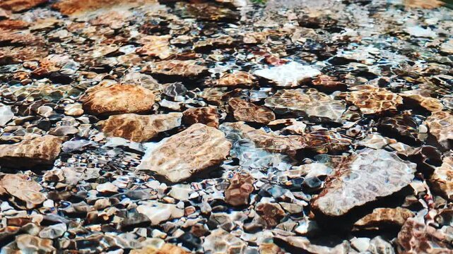 Cool summer river water flowing over rocks in slow motion