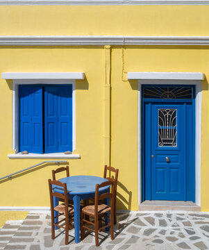 Traditional Yellow House with Blue Doors and Shutters in Karpathos, Greece
