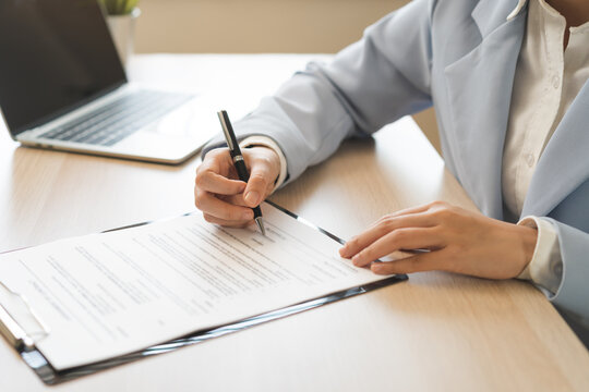 Business finance concept, asian young woman hand document signing contract, holding pen putting signs signature paper at desk office. Agreement legal commitment job, approval permission confirmation.