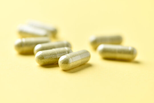 Barley grass capsules. Antioxidants. Concept for a healthy dietary supplementation. Bright background. Soft focus. Close up. Copy space.