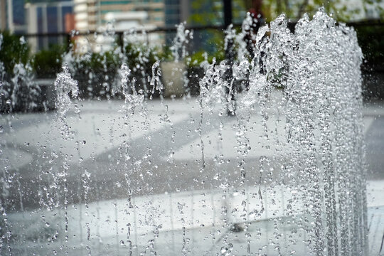 Close-up of water jets in a modern urban fountain with blurred background