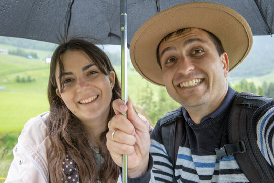 Happy couple enjoying a rainy day in Val di Funes