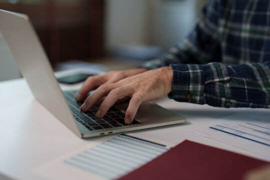 Person typing on laptop, managing business finances and documents, working from home or office, showing hands on keyboard, performing remote work, online learning, and data entry