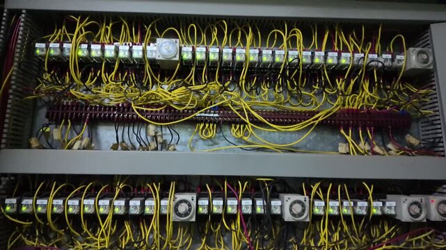 The junction box has numerous wires secured neatly with screws for Programmable Logic Controller or PLC