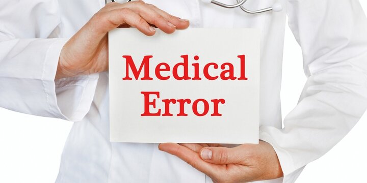 Medical error sign, doctor holding malpractice warning card