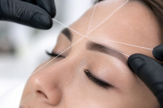 Professional brow mapping procedure with white thread