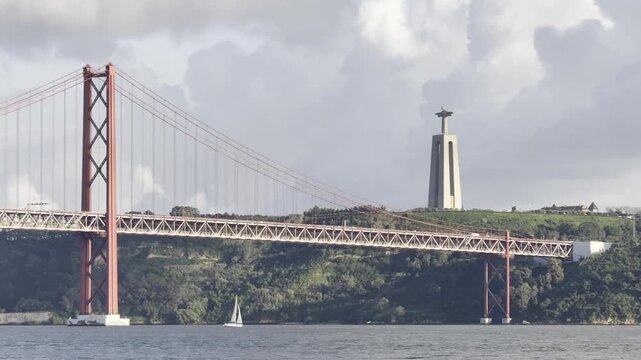 A famous tourist attraction in Lisbon that connects Lisbon and Almada, shrouded in thick fog with yachts passing beneath it. Lisbon, Portugal

