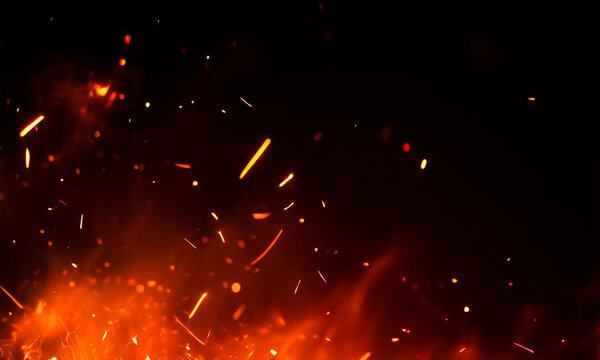 Fiery sparks and embers rising against a dark black background dramatic illumination