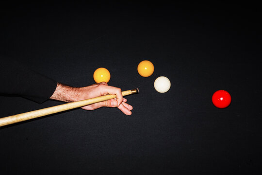 Player Making a Shot in a Billiards Game With Colorful Balls