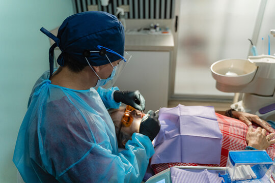 Dental professional examining oral cavity of a patient