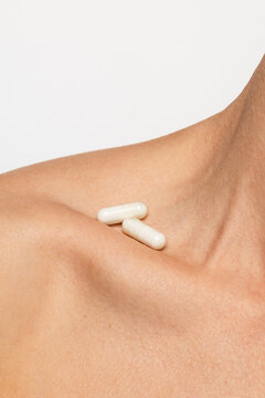 Pills Placed on the Collarbone Area of a Person's Neck