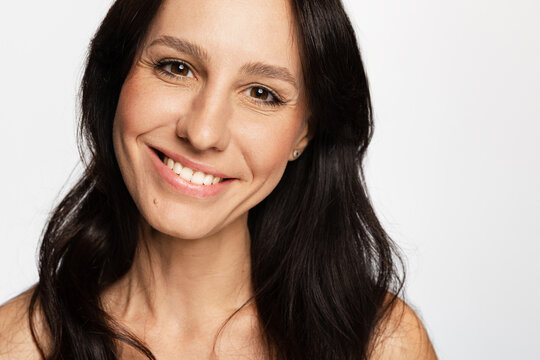 Smiling woman looking at camera on white background