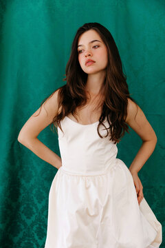 Young brunette woman posing in elegant white dress