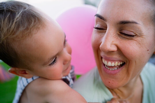 Mother and child sharing joyful family moment with pink balloon