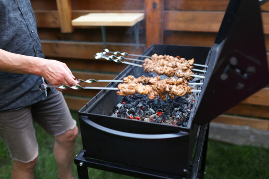 A man is preparing food on the grill.