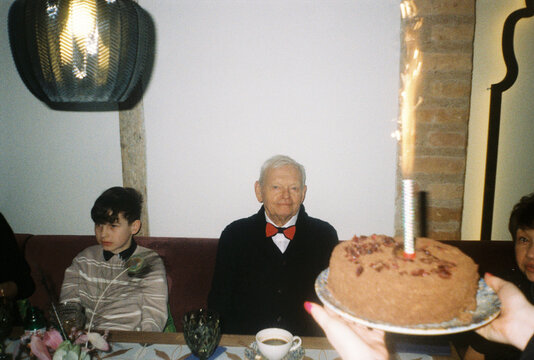 Family Celebrates Birthday With Cake and Guests in Cozy Setting