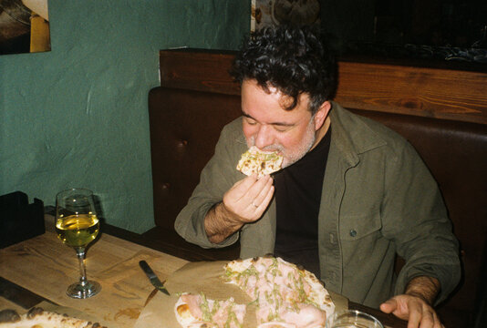 Man Enjoys Pizza at a Restaurant 