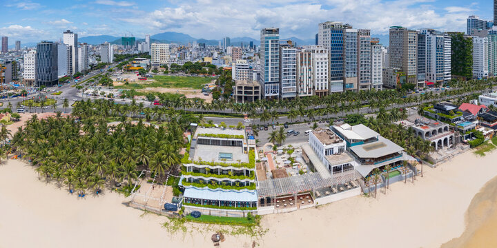 Beachfront cafes and bars in front of high rise city buildings 