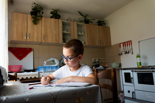 Young Boy Drawing at Kitchen Table
