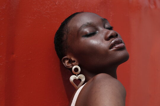 Portrait of a young lady on a outdoor red background 