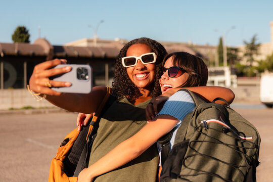 Teenage girls taking selfie with school backpacks